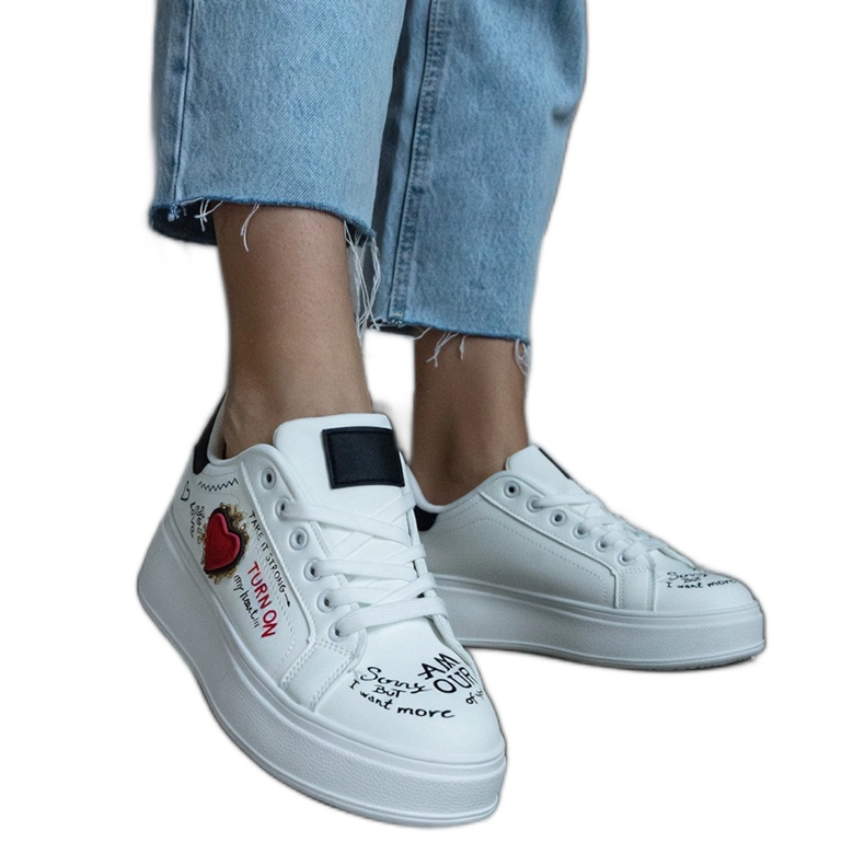 Białe sneakersy ozdobione naszywką i napisami na platformie