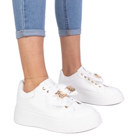 Białe sneakersy zdobione kokardką i złotym misiem